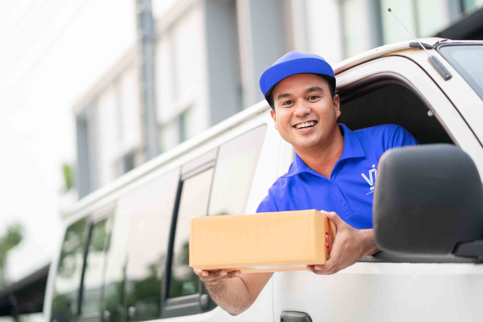 young-delivery-man-blue-uniform-driving-truck-sending-parcel copy